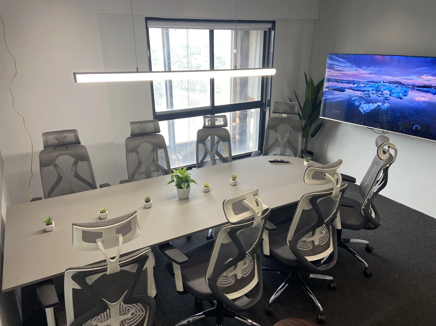 Casual workspace area with modern desks and green accent chairs